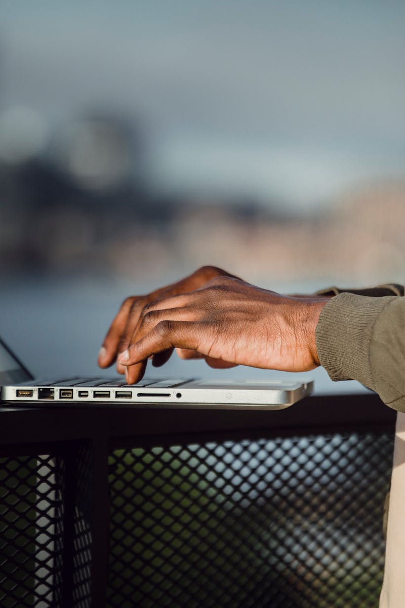 Crop man working on laptop on open terrace